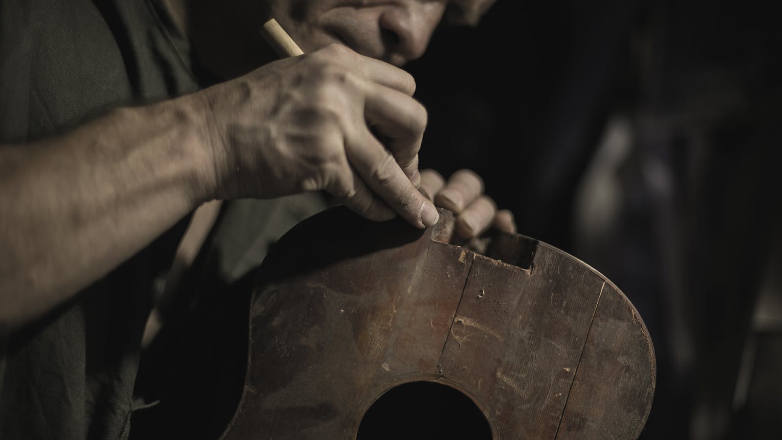 luthier trabalhando na fabricação de instrumento musical em oficina especializada